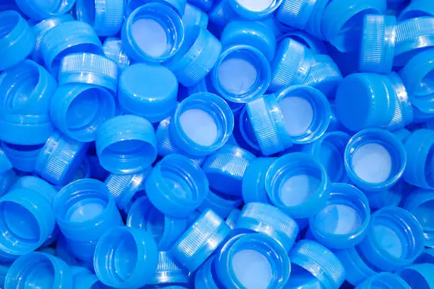 Photo of group of plastic bottle caps are ready to send to production line in drinking water factory.