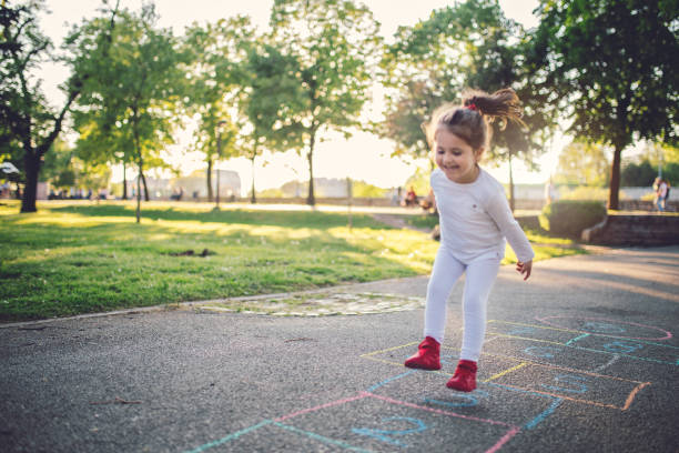 счастливый ребенок на детской площадке - hopscotch стоковые фото и изображ�ения