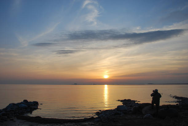 istock Photographer capturing the sunset by seaside 952019566