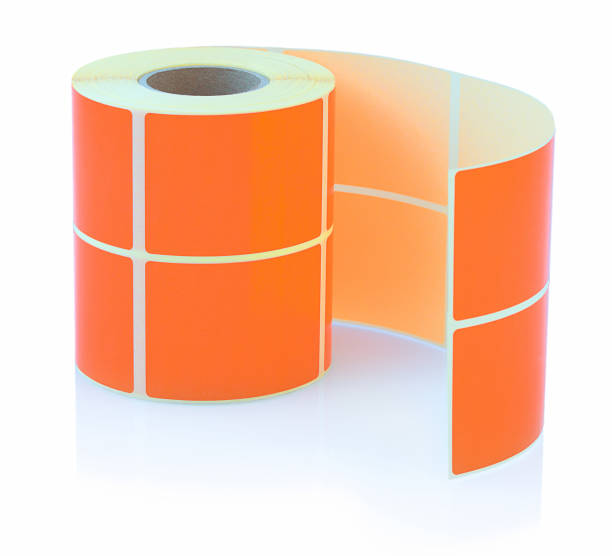 istock Orange label roll isolated on white background with shadow reflection. Color reel of labels for printers. Labels for direct thermal or thermal transfer printing. 952020004