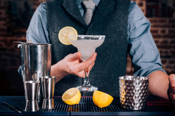istock Bartender serving drinks at bar, pub or restaurant. Cocktail, alcoholic beverages at bar with margarita ready to drink 952020780
