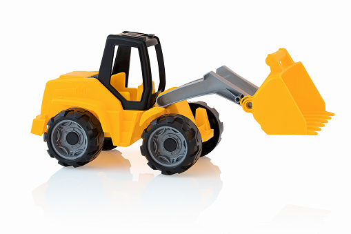 Yellow excavator isolated on white background with shadow reflection. Plastic child toy on white backdrop. Construction vehicle. Children's toy. Tractor toy.