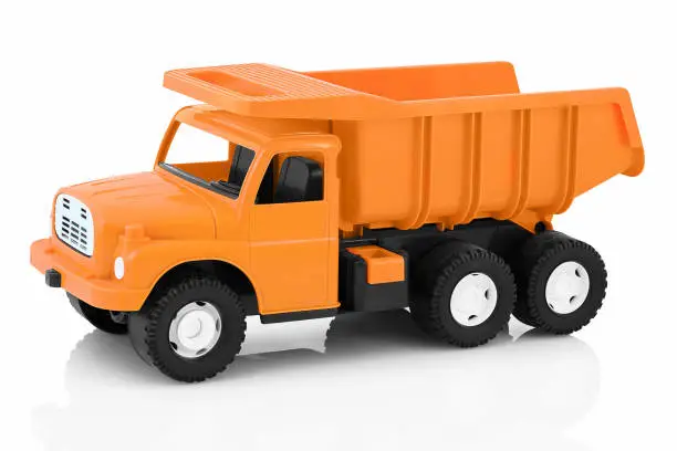 Photo of Vintage dump truck isolated on white background with shadow reflection. Plastic child toy on white backdrop. Dump tipper truck lorry construction vehicle.