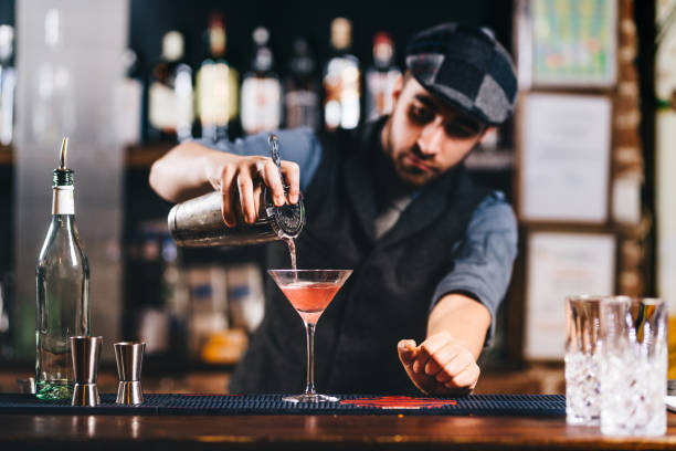 ritratto di barista vintage al bar. versando e preparando cocktail - cocktail transparent cocktail shaker glass foto e immagini stock
