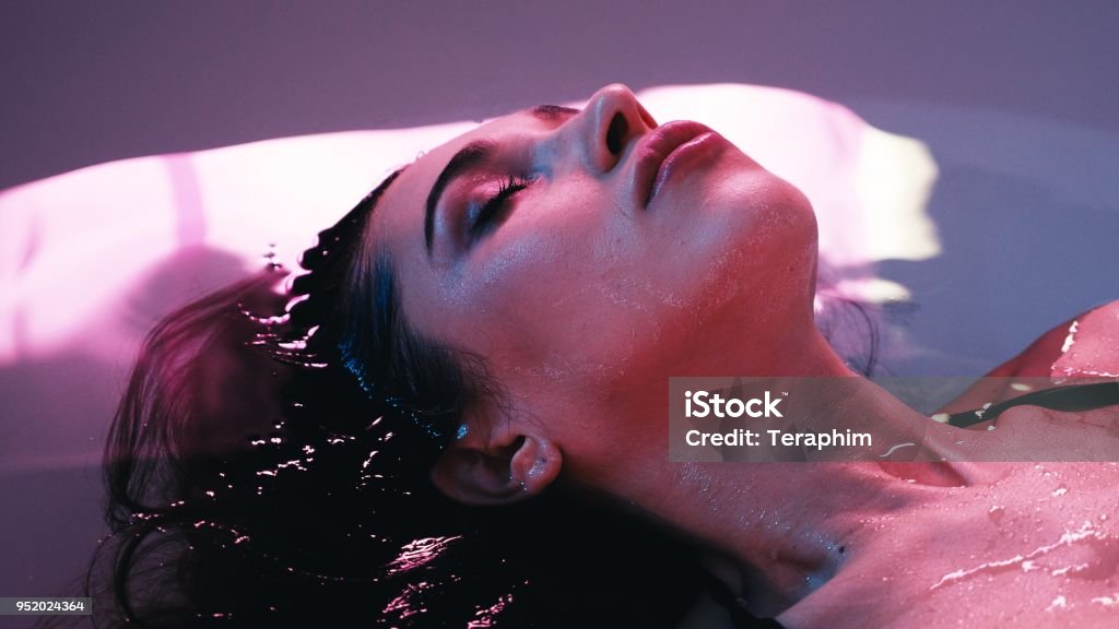 Young woman floating in Spa bath or swimming pool, she is very relaxed. Welness concept Young woman floating in Spa bath or swimming pool, she is very relaxed. Welness concept. Storage Tank Stock Photo