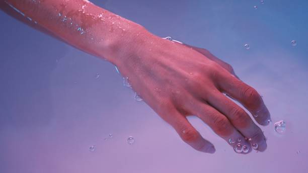 Young womans hand floating in Spa bath or swimming pool, she is very relaxed. Welness concept Young womans hand floating in Spa bath or swimming pool, she is very relaxed. Welness concept. slow motion face stock pictures, royalty-free photos & images