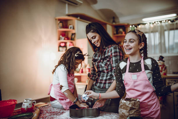 istock Mother Teaching her Two Daughters How To Make Christmas Cookies 952028298