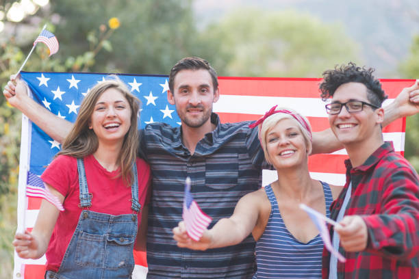 istock Group of millennial friends hold American flags 952035752