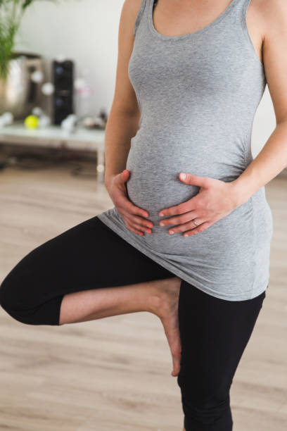istock Pregnant woman doing prenatal yoga standing in tree pose 952037448
