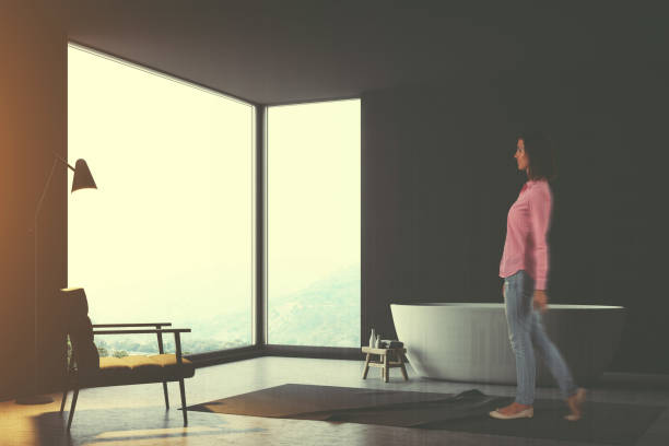 istock Panoramic gray bathroom corner, an armchair, woman 952038638