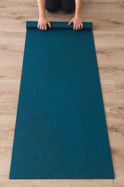 istock Woman laying out yoga mat in a studio 952041580