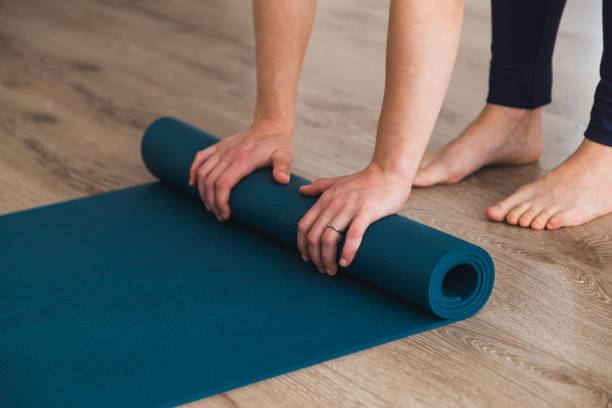 istock Woman unrolling her yoga mat in a studio 952041652