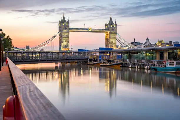 Panorama of Tower Bridge with boats moored and reflection in river thames, London. England