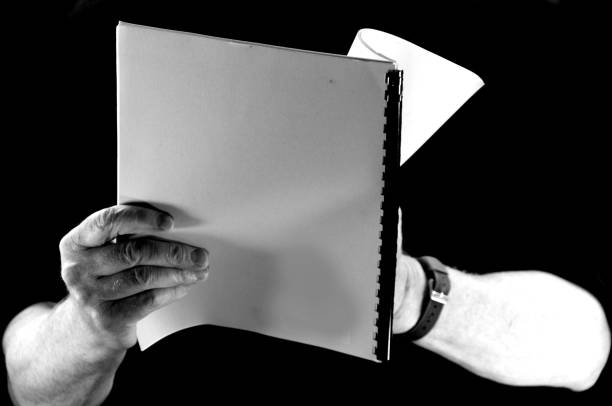istock Man's hand holding an open book black background 952050214