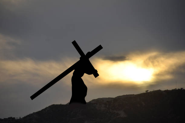 A wooden cross at the peak of a rocky mountain in Lebanon, the Bekaa Valley and Syria in the distance