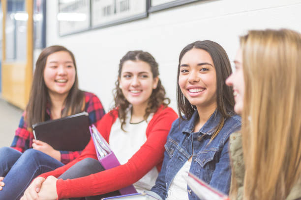 istock High school girls sit in hall by lockers 952051756