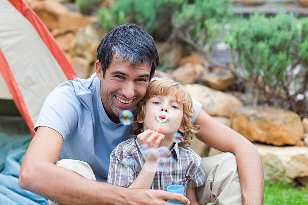 istock Father and son blowing bubbles in a tent 95205447
