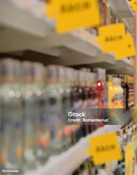 Blurred Section Bottles Of Spirit Hard Liquor At Retail Store In Europe Aisle In Local Supermarket Defocused Background Stock Photo - Download Image Now