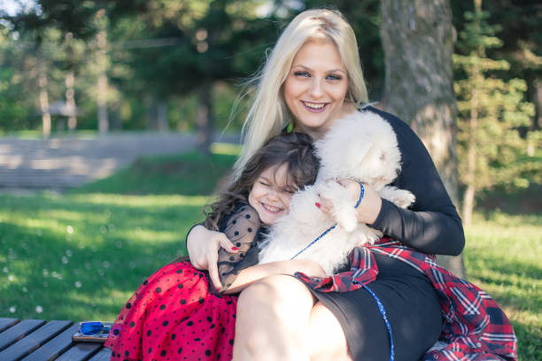 istock happy mother and daughter with poodle dog. 952057228