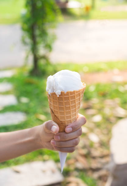 istock Ice cream scoop cone in woman hand. 952059198
