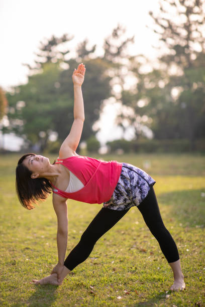 istock Young woman practicing yoga at public park 952059512