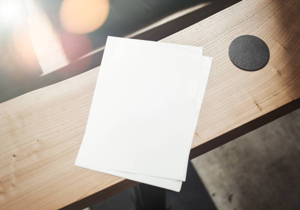 istock Beerdeckel and blank sheet A4 are on wooden table. 952061442