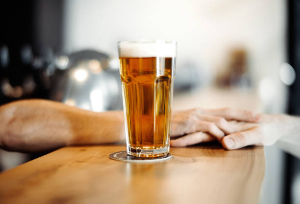 istock Bartender man gives beer glass to a customer. 952061674