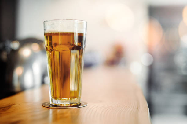 istock Beer glass stands on bar counter. 952061878