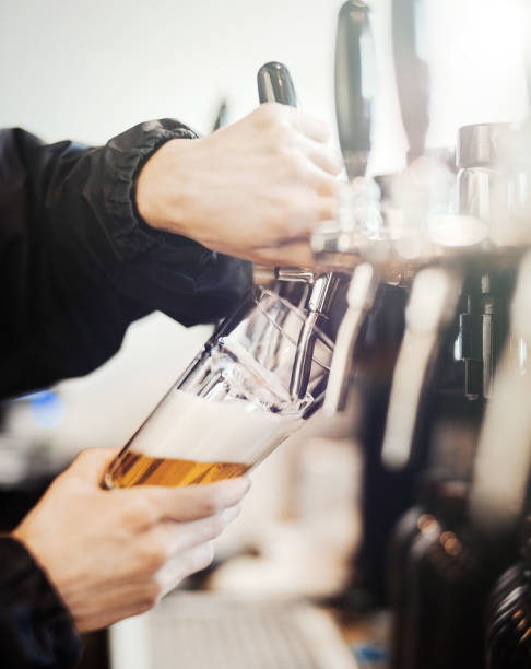 istock Bartender man poors glass of beer. 952062132