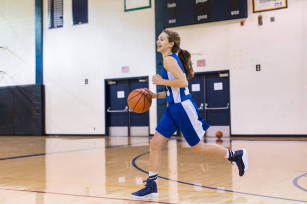 mädchen-high school basketball-spieler dribbelt sich das gericht - basketballmädchen stock-fotos und bilder