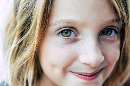 Close up portrait of a beautiful and very cute green eyed little girl, 7 years old and cheerful