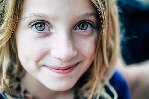 Close up portrait of a beautiful and very cute green eyed little girl, 7 years old and cheerful