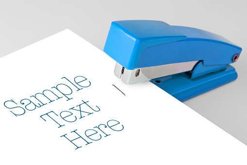 Blue stapler lies on a white background