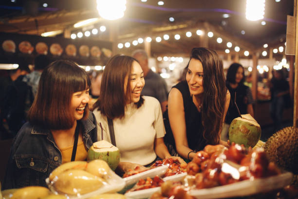 amigos disfrutando de la noche tiempo de mercados de alimentos en bangkok - asian cuisine fotografías e imágenes de stock