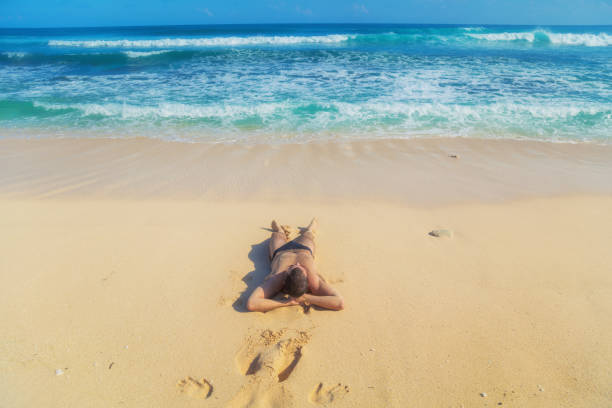 Man lying and enjoying on a sandy tropical beach.