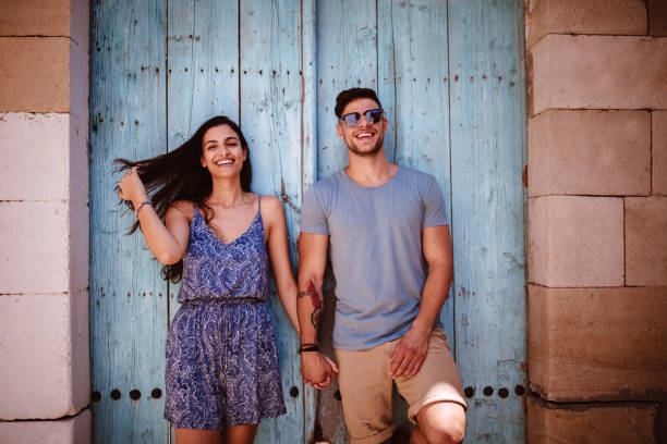 los turistas jóvenes hipster par las manos de explotación contra la vieja puerta - couple old fashioned hipster holding hands fotografías e imágenes de stock