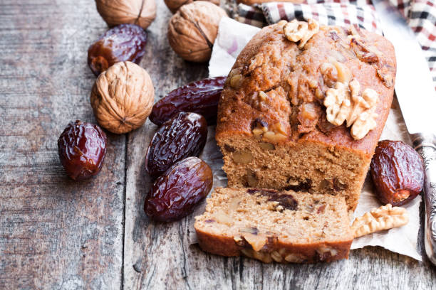Homemade  date and walnut loaf cake on old wooden table Homemade  date and walnut loaf cake on old wooden table date fruit stock pictures, royalty-free photos & images