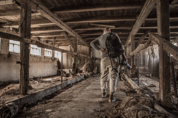 istock Middle Aged Redhead Handsome Man photographer journalist in decayed old abandoned farmhouse 952085608