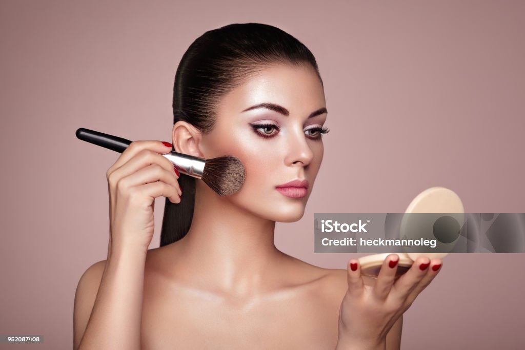 Beautiful Woman applies Skin Tone with Brush Beautiful Woman applies Skin Tone with Brush. Beautiful Woman face. Perfect Makeup. Skincare Foundation. Brushes Makeup Artist Make-Up Stock Photo