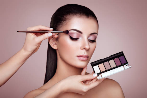 makeup artist applies eye shadow - make up imagens e fotografias de stock