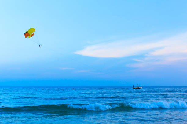 istock Colorful parasail wing pulled by boat in the sea water. 952090064