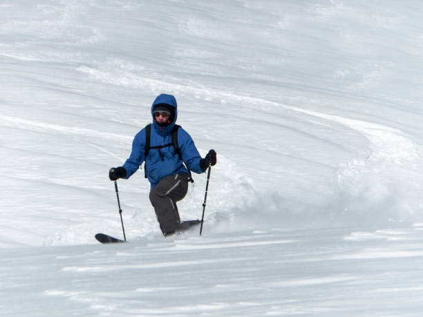 male backcountry skier telemark skiing in the Alps in fresh powder male backcountry skier telemark skiing in the Alps in fresh powder on a beautiful day in winter arosa photos stock pictures, royalty-free photos & images