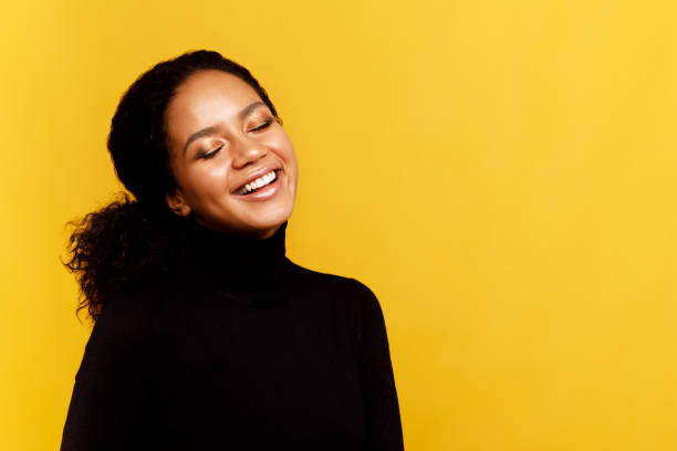 istock Happy woman with her eyes closed over yellow background 952097366