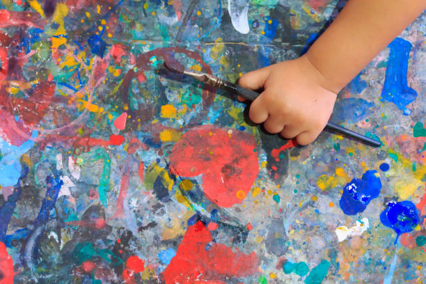 Hand baby holding brush paint color.