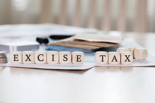 Word EXCISE TAX is composed of wooden letters. Closeup