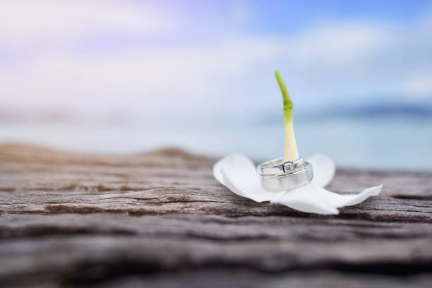 Wedding rings with wooden table on the beach background