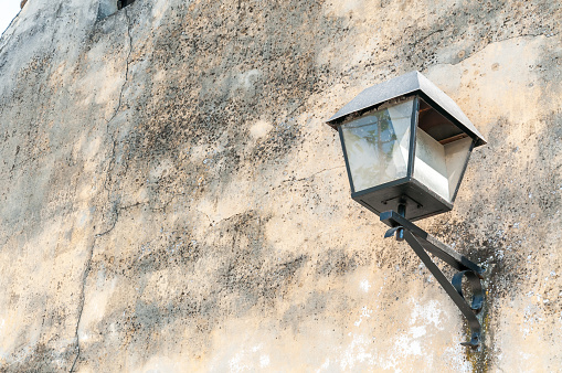 Black street lamp or lantern on the exterior wall facade of house to provide light at the night