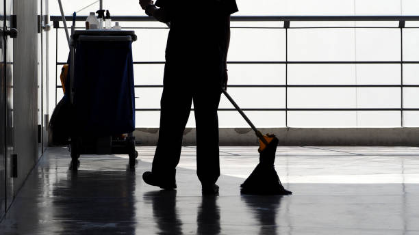 Silhouette image of cleaning service people sweeping floor with mop Silhouette image of cleaning service people sweeping floor with mop and other equipment on trolley. custodian silhouette stock pictures, royalty-free photos & images