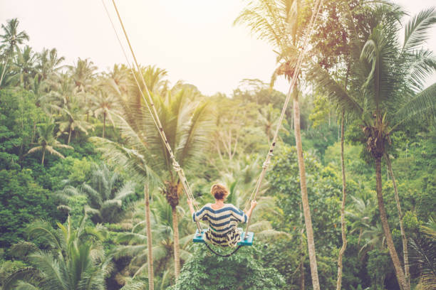 istock Young woman swinging over the jungle, Bali 952105232