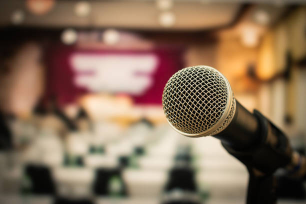 istock Microphone on abstract blurred of speech in seminar room or speaking conference hall light, Speaker lecture Concept 952105268